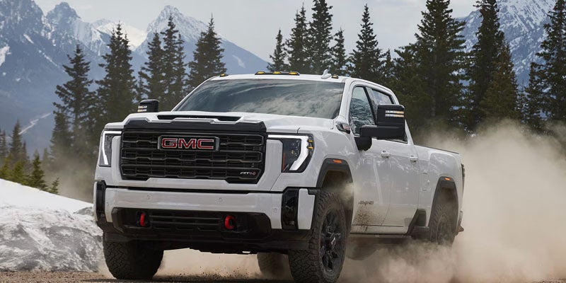 White 2026 GMC Sierra 2500HD cruising on dirt road