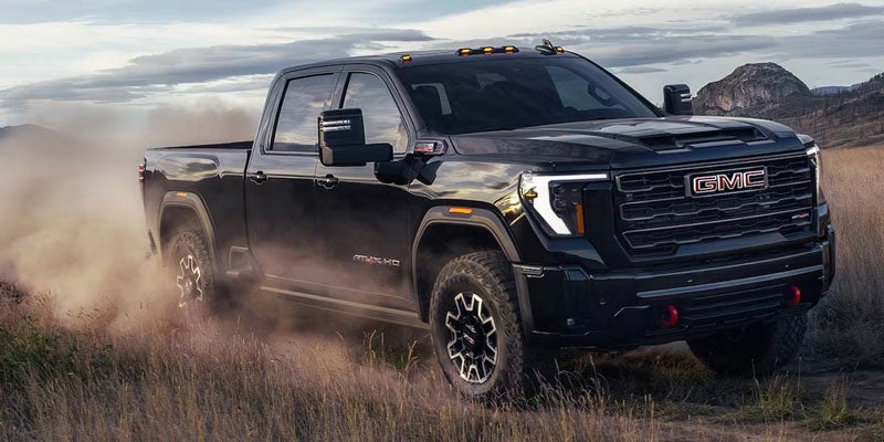 2026 GMC Sierra 3500HD in black cruising through dirt road